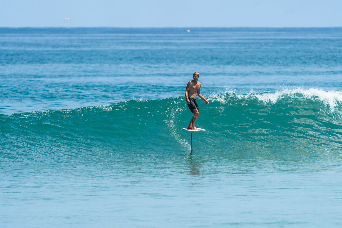 Student learning surf foil skills in the ocean with REAL coaching